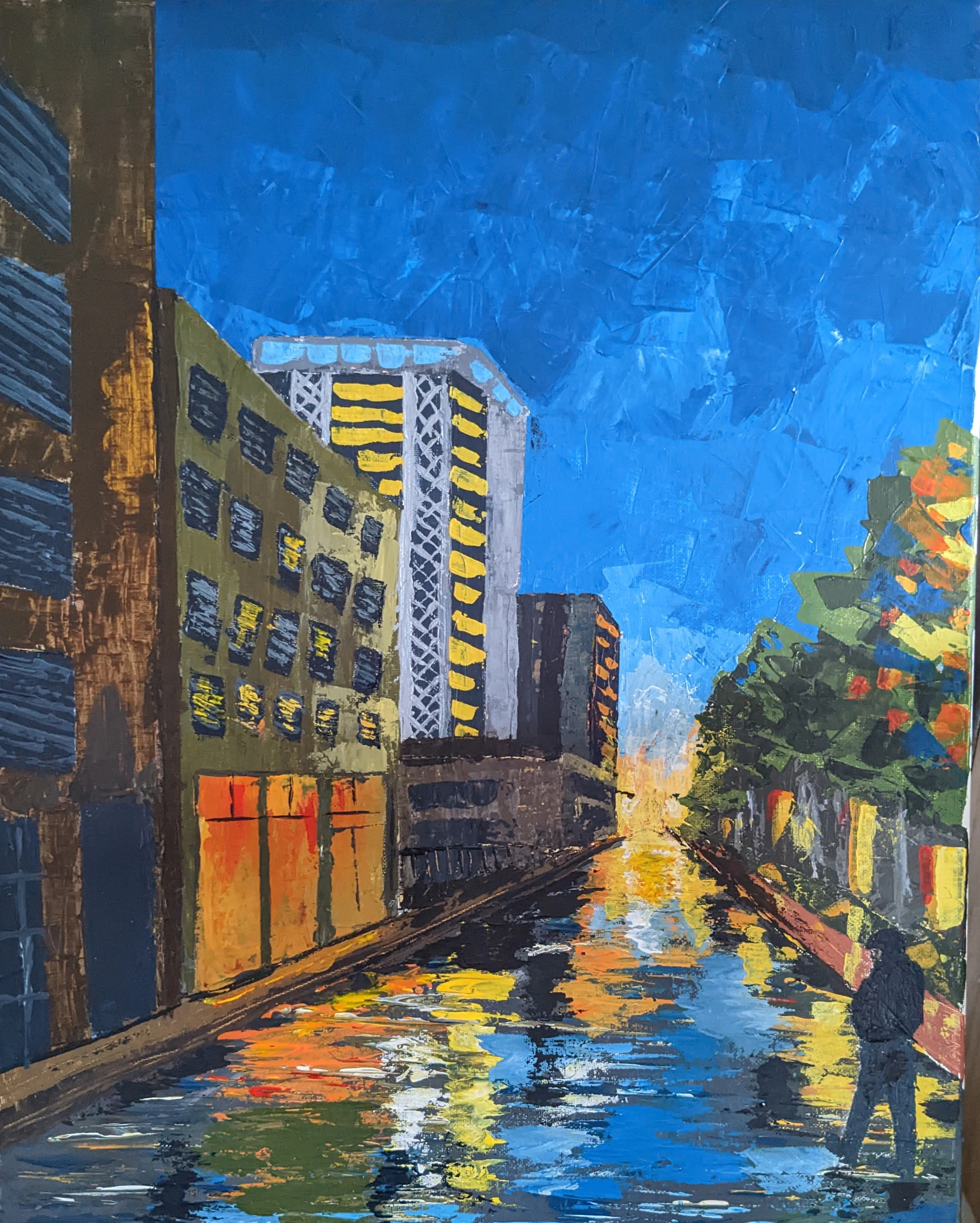 Palette-knife acrylic painting of a city street at night, with lit windows and warm reflections on a wet road beneath a deep blue sky.