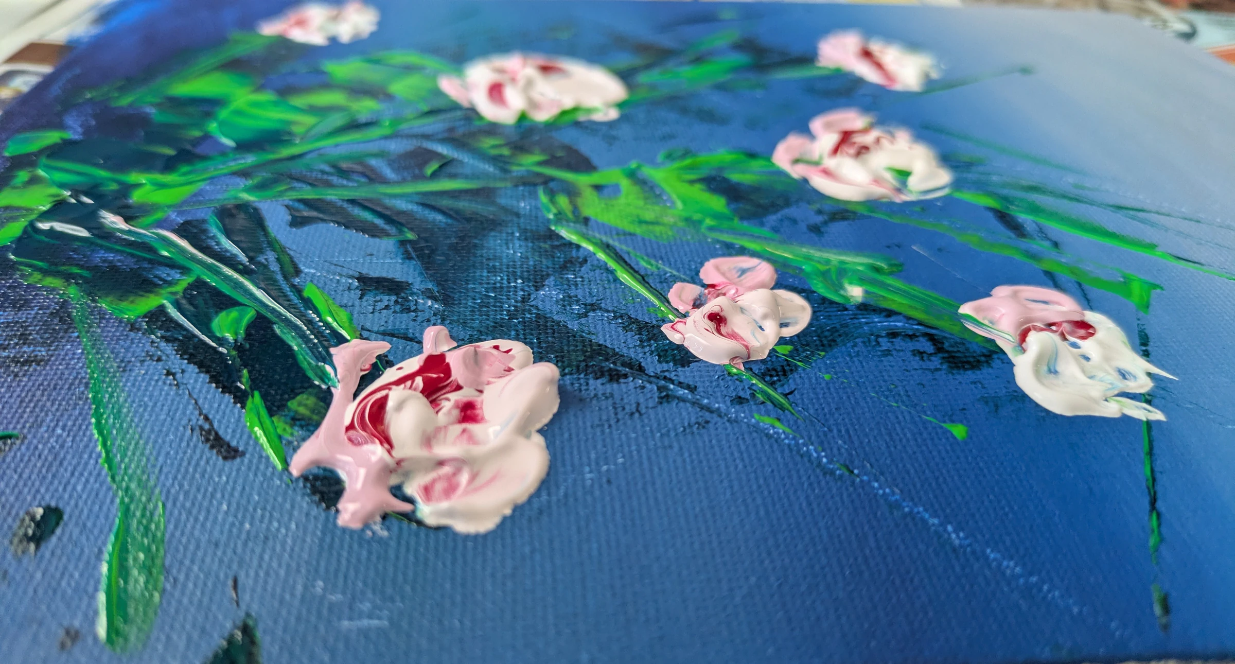Detail of Roses, an impasto acrylic painting of pink roses with thickly textured petals on a deep blue background.